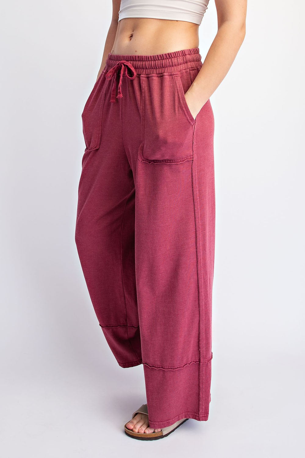 woman wearing maroon wide leg lounge pants with pockets and drawstring waist