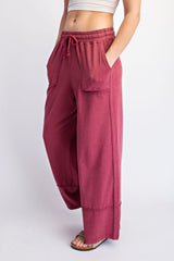 woman wearing maroon wide leg lounge pants with pockets and drawstring waist