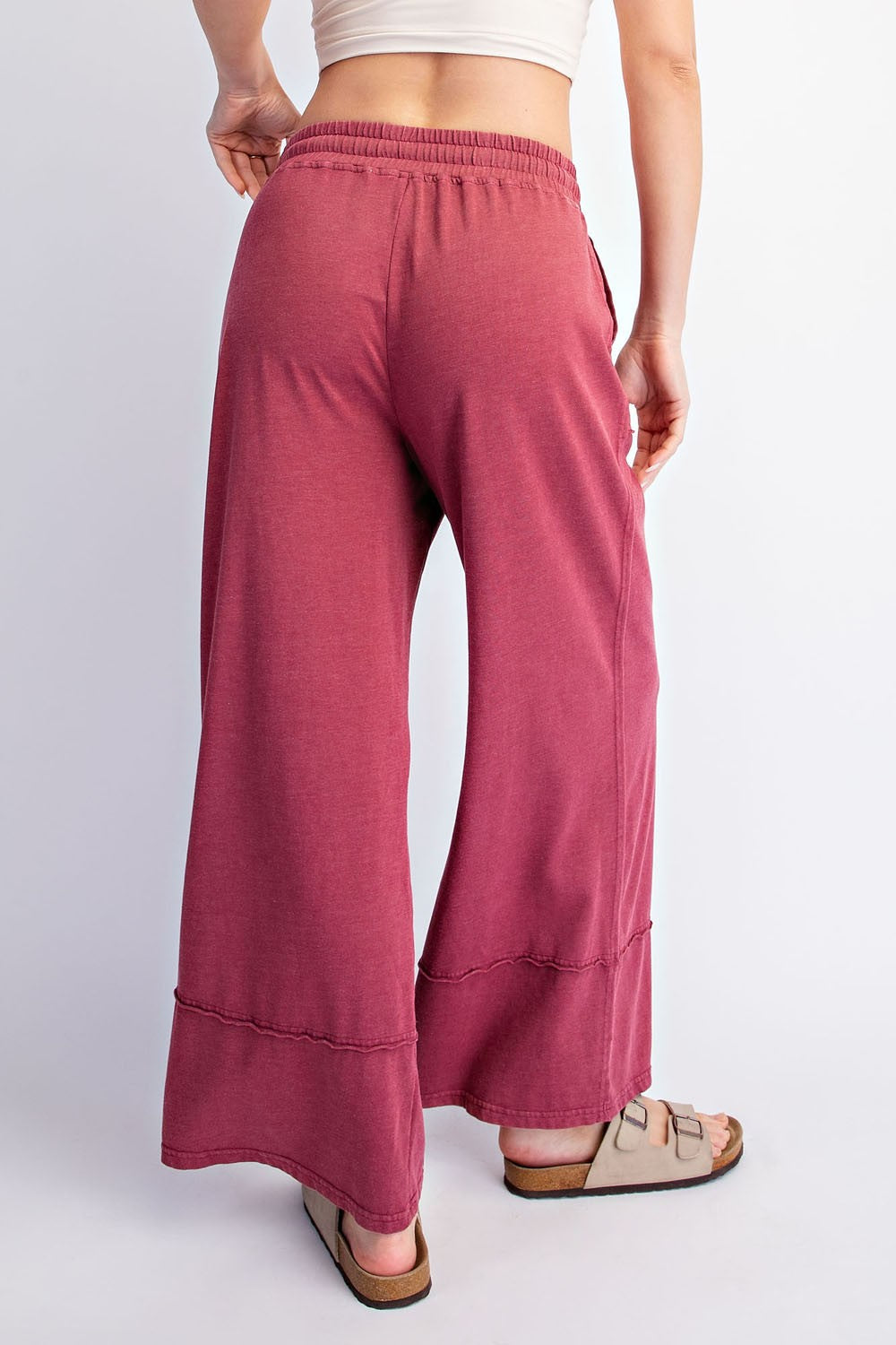 woman wearing blush pink wide-leg pants with a relaxed fit and an elastic waistband, seen from the back