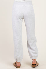 woman wearing gray maternity jogger pants with elastic waistband and ankle cuffs, showing the back view