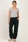 woman wearing a gray short sleeve maternity top and green maternity jogger pants, styled with light footwear and glasses