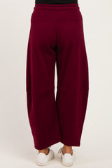 woman wearing maroon maternity wide-leg pants, shown from the back