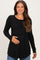 woman wearing a black long sleeve maternity top and holding her baby bump