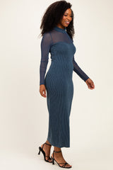 woman wearing a dark blue ribbed knit midi dress with a sheer long sleeve top and heeled sandals