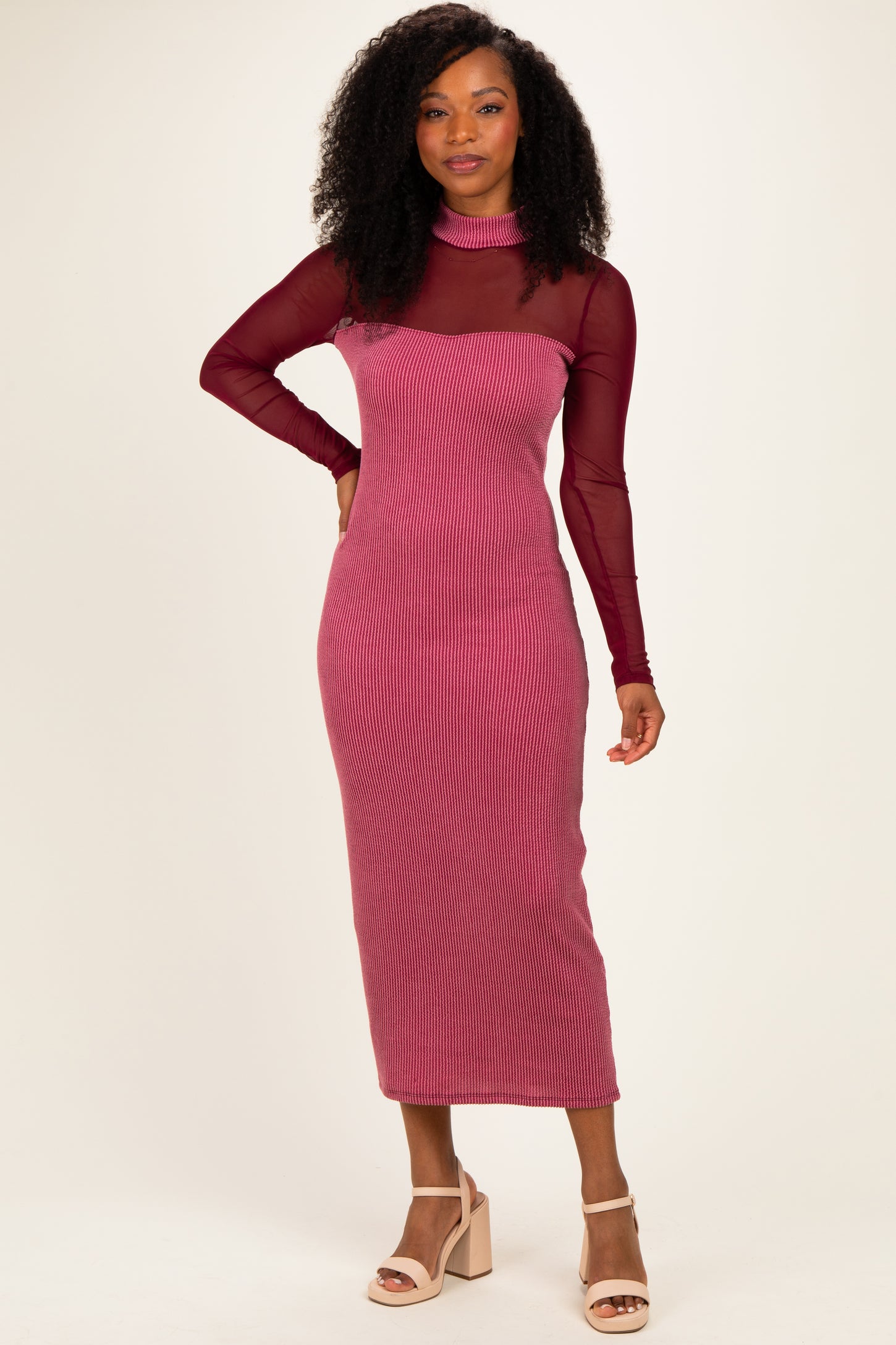 woman wearing a burgundy ribbed midi dress with a turtleneck and long sheer sleeves