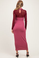 woman wearing a burgundy maternity dress with a sheer back and ribbed texture, styled with strappy heels