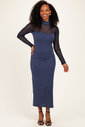 woman wearing a navy striped long sleeve midi dress with a sheer neckline and black strappy heels