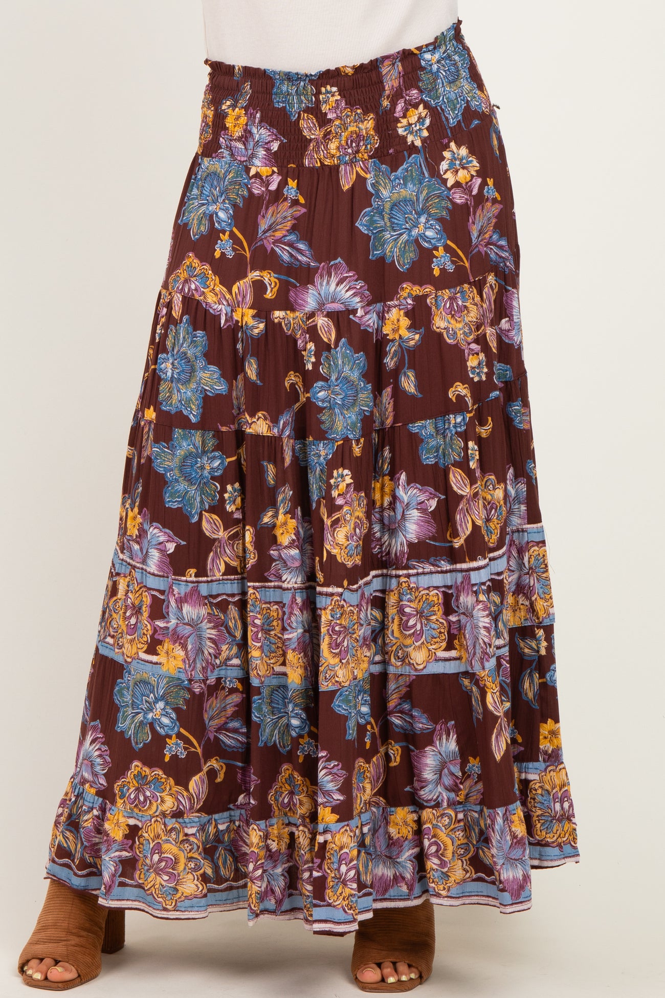 woman wearing a burgundy floral maxi skirt with ruffles and smocked waistband