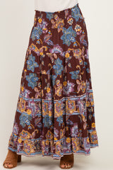 woman wearing a burgundy floral maxi skirt with ruffles and smocked waistband