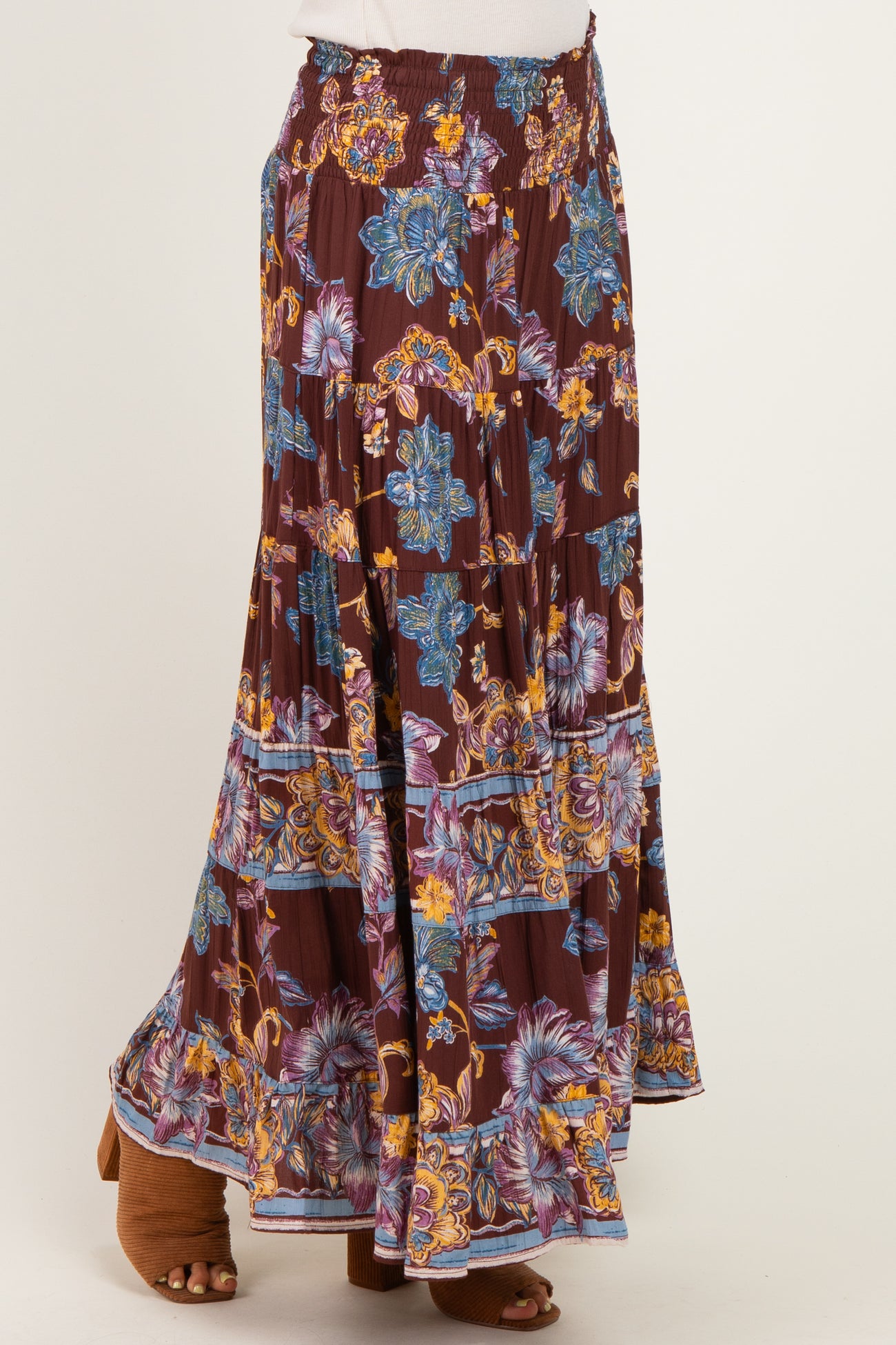 woman wearing a burgundy floral maxi skirt with a smocked waistband and layered ruffle hem