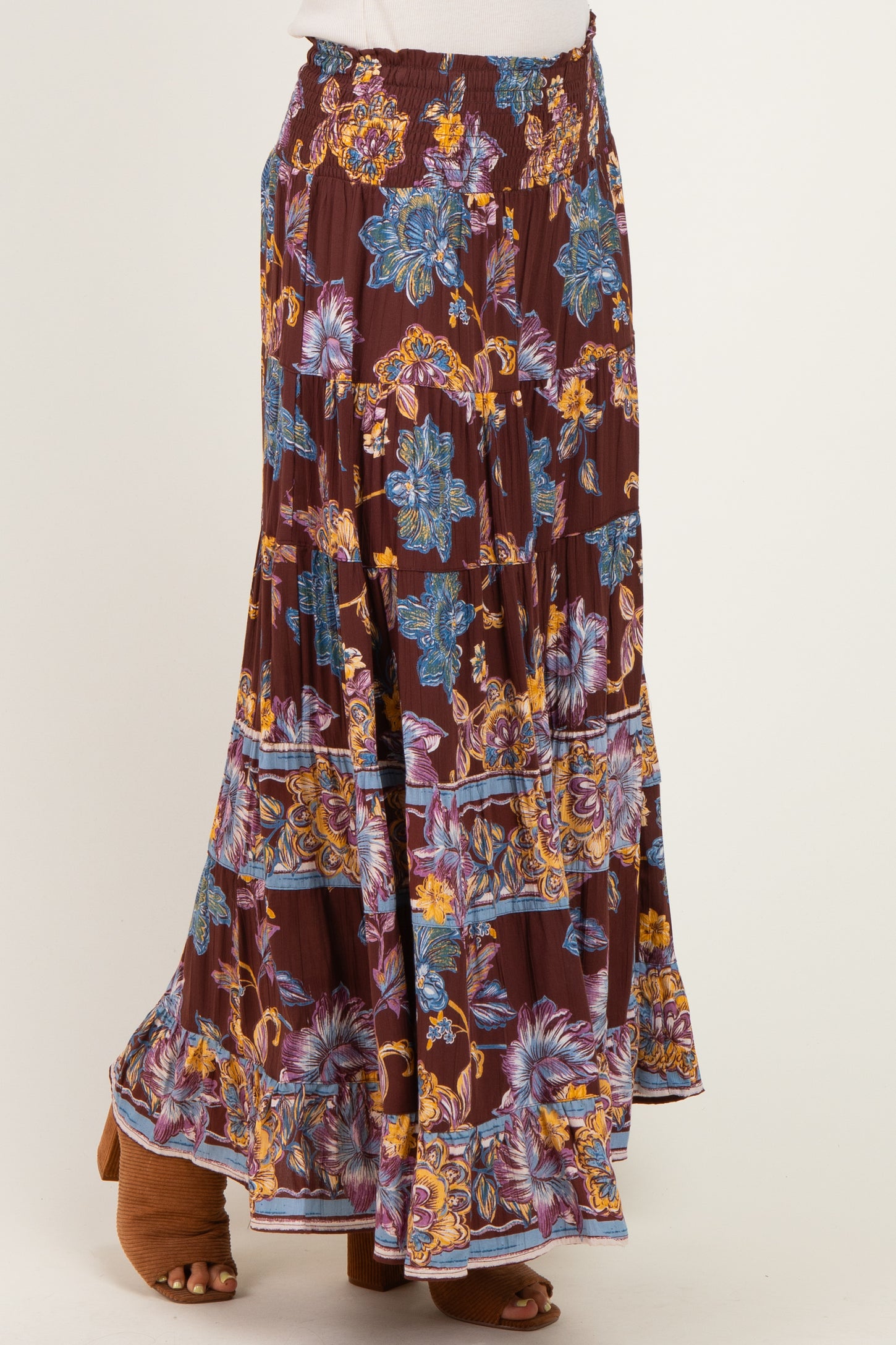 woman wearing a burgundy floral maxi skirt with a smocked waistband and layered ruffle hem