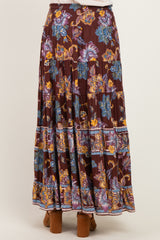 woman wearing a burgundy floral maxi skirt with layered ruffles and colorful floral patterns