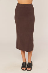 woman wearing a brown ribbed midi skirt and black slide sandals