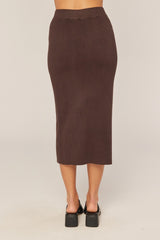 woman wearing a brown ribbed midi skirt, viewed from the back, with a fitted silhouette and high waist