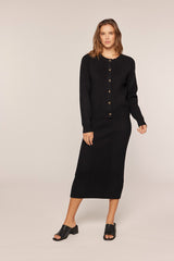 woman wearing a black cardigan and matching midi skirt with buttons and a straight silhouette