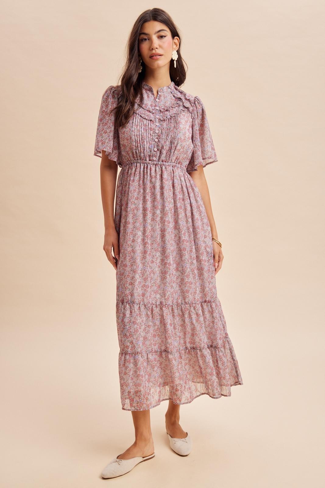 woman wearing a pink floral maxi dress with puff sleeves and tiered ruffles