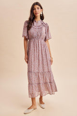 woman wearing a pink floral maxi dress with puff sleeves and tiered ruffles