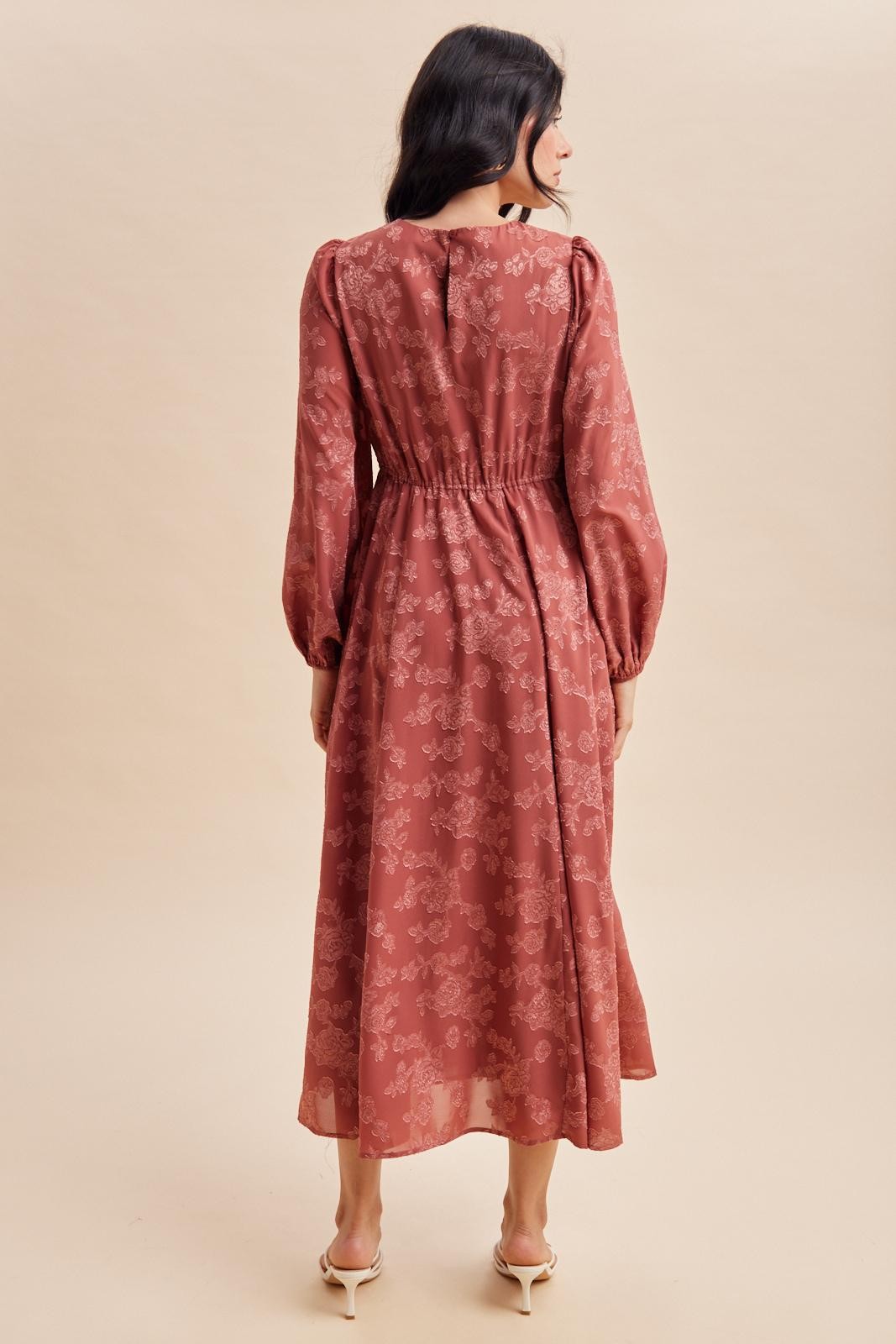 woman wearing a dusty rose floral long sleeve maxi dress with a cinched waist viewed from the back