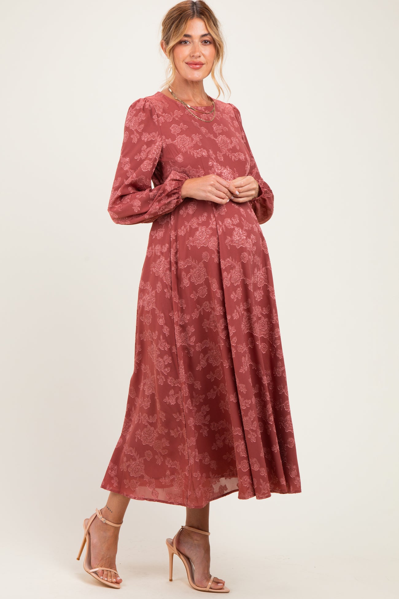 woman wearing a dusty rose long sleeve maternity dress with floral print and visible baby bump