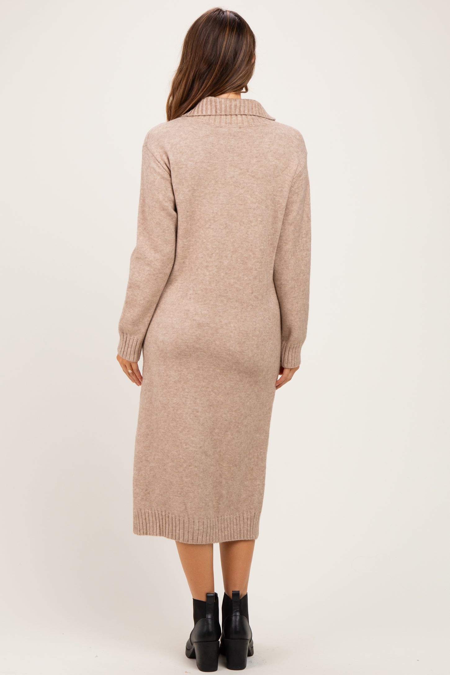 woman wearing a beige long sleeve maternity sweater dress with a collar and ribbed hem, showing her back