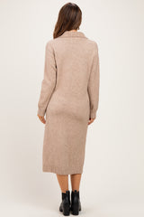 woman wearing a beige long sleeve maternity sweater dress with a collar and ribbed hem, showing her back