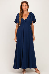 woman wearing a navy blue maxi dress with short flutter sleeves and a fitted bodice