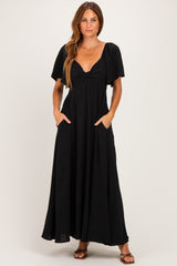 woman wearing a black maxi dress with short sleeves, v-neckline, and pockets