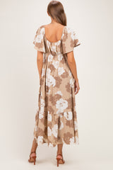 woman wearing a brown floral maternity maxi dress with flutter sleeves and a tiered hem, showing her baby bump from the back