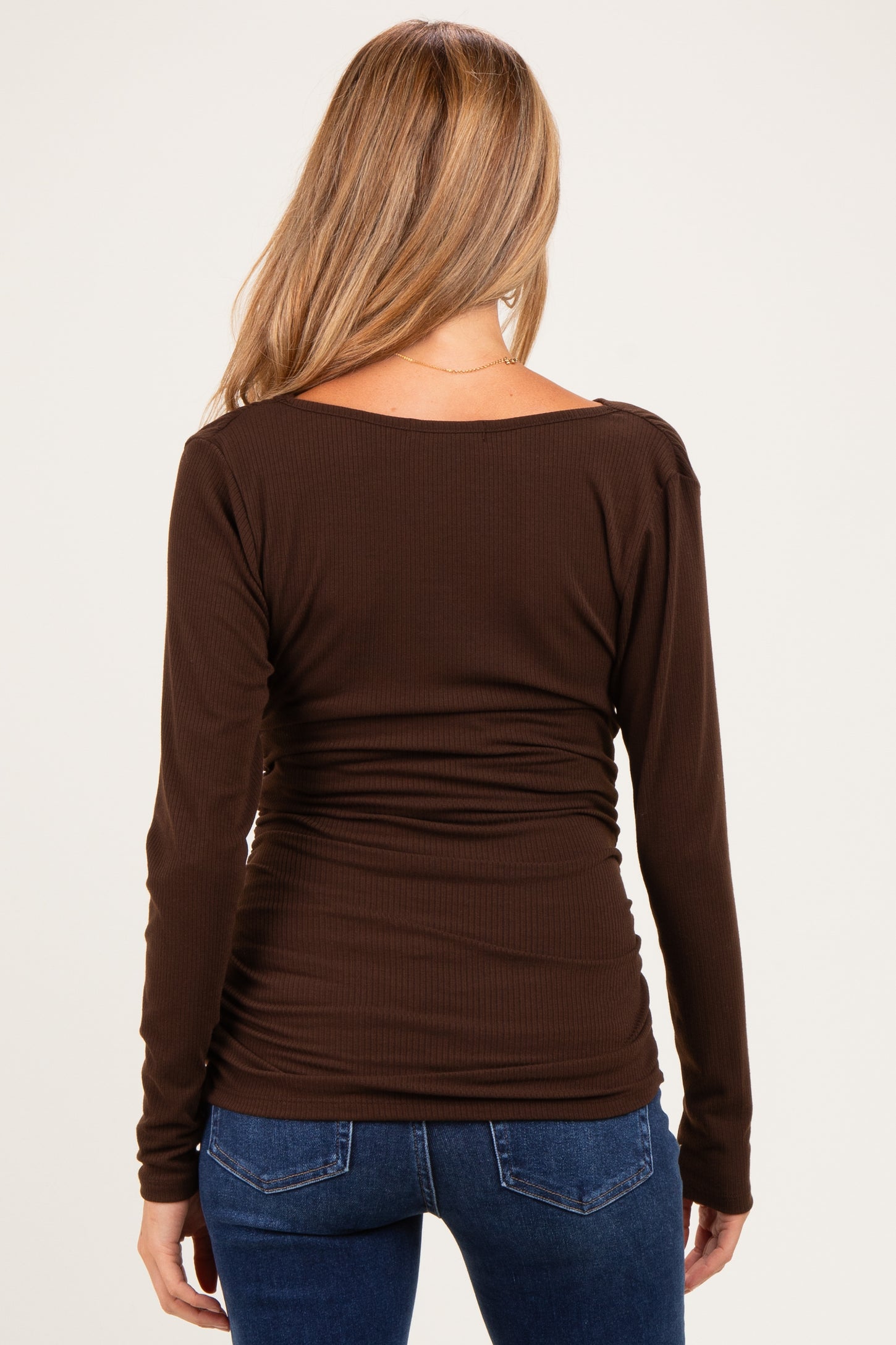 woman wearing a brown long sleeve maternity top with gathered detailing, viewed from the back