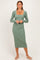 woman wearing a long sleeve ribbed midi dress in sage green with a square neckline and gathered side details