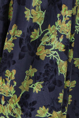 navy blue dress with vibrant green floral pattern and delicate pleats