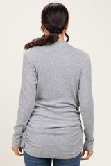 woman wearing a gray long sleeve ribbed sweater with gathered side details, viewed from the back
