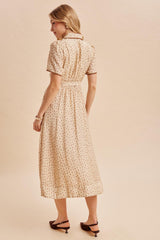 woman wearing a beige midi dress with floral print and short sleeves, seen from the back