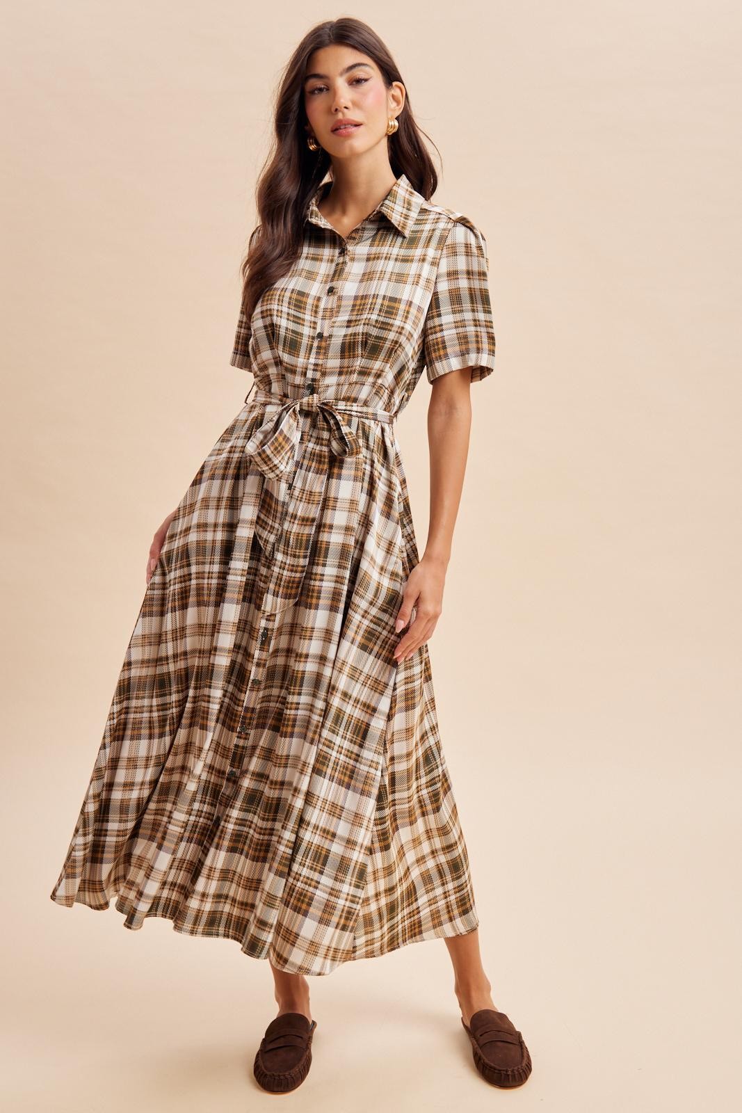 woman wearing a brown and cream plaid button-down maxi dress with a tie waist and short sleeves