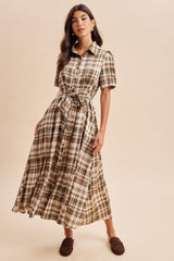 woman wearing a brown and cream plaid button-down maxi dress with a tie waist and short sleeves