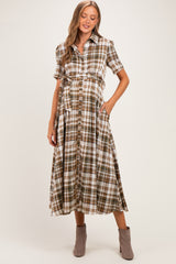 woman wearing a brown and white plaid maternity dress with short sleeves and a waist tie, showcasing her baby bump