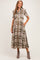 woman wearing a brown and white plaid maternity dress with short sleeves and a waist tie, showcasing her baby bump