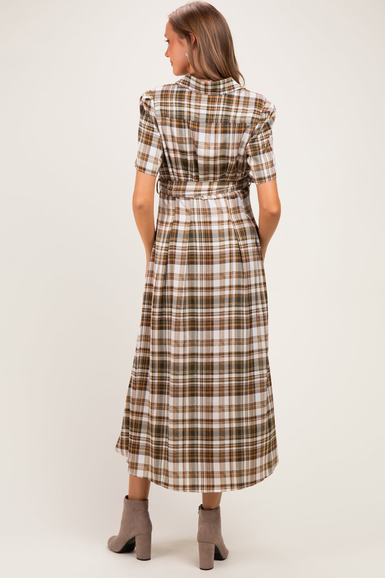 woman wearing a brown and white plaid maternity dress with short sleeves and a tied waist, showing off her baby bump from behind