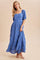 woman wearing a blue maxi dress with puff sleeves and floral embroidery