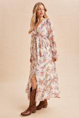 woman wearing a floral maxi dress with a deep v-neck and long sleeves, paired with brown cowboy boots