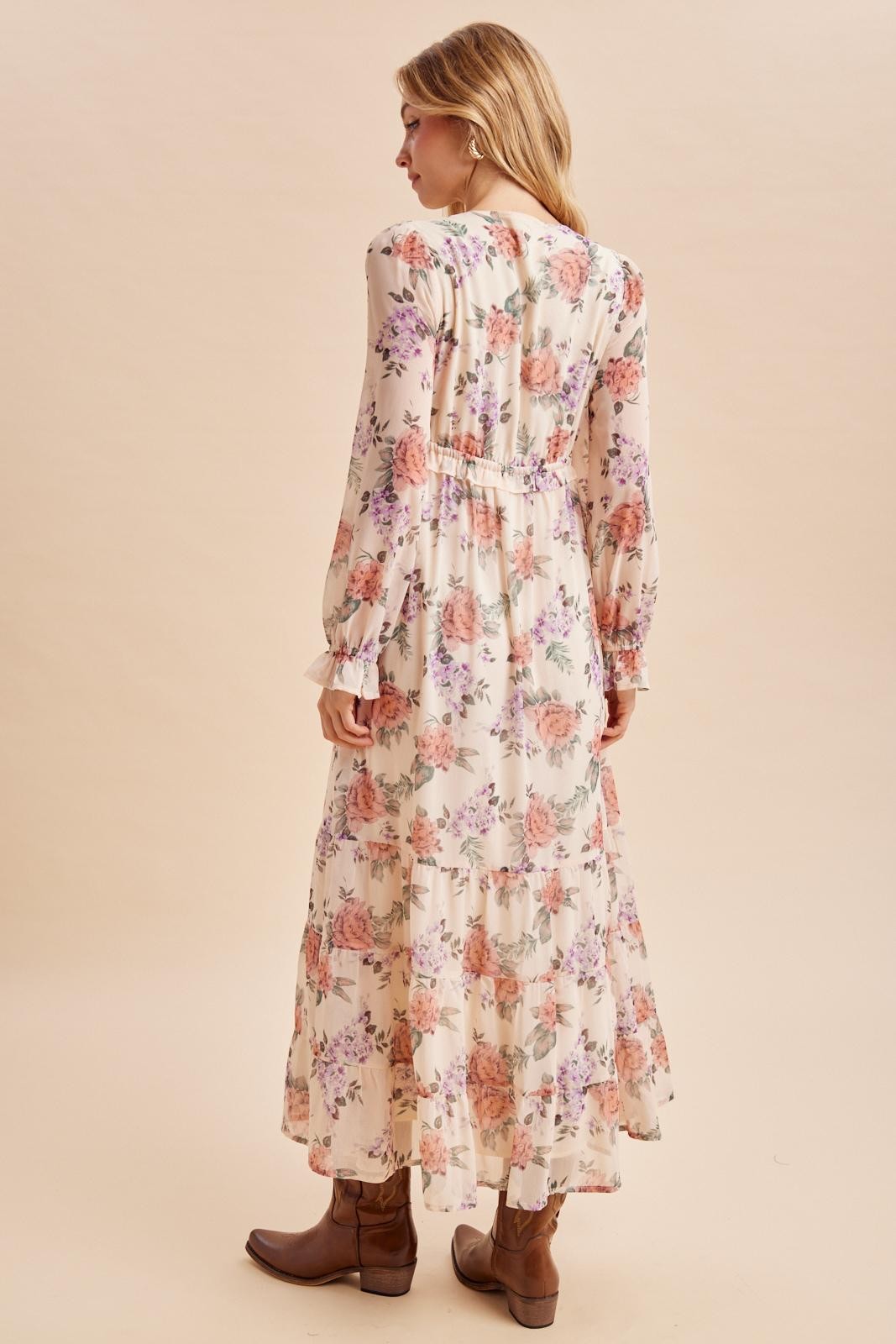 woman wearing a long sleeve floral maxi dress with tiered ruffles and tan ankle boots