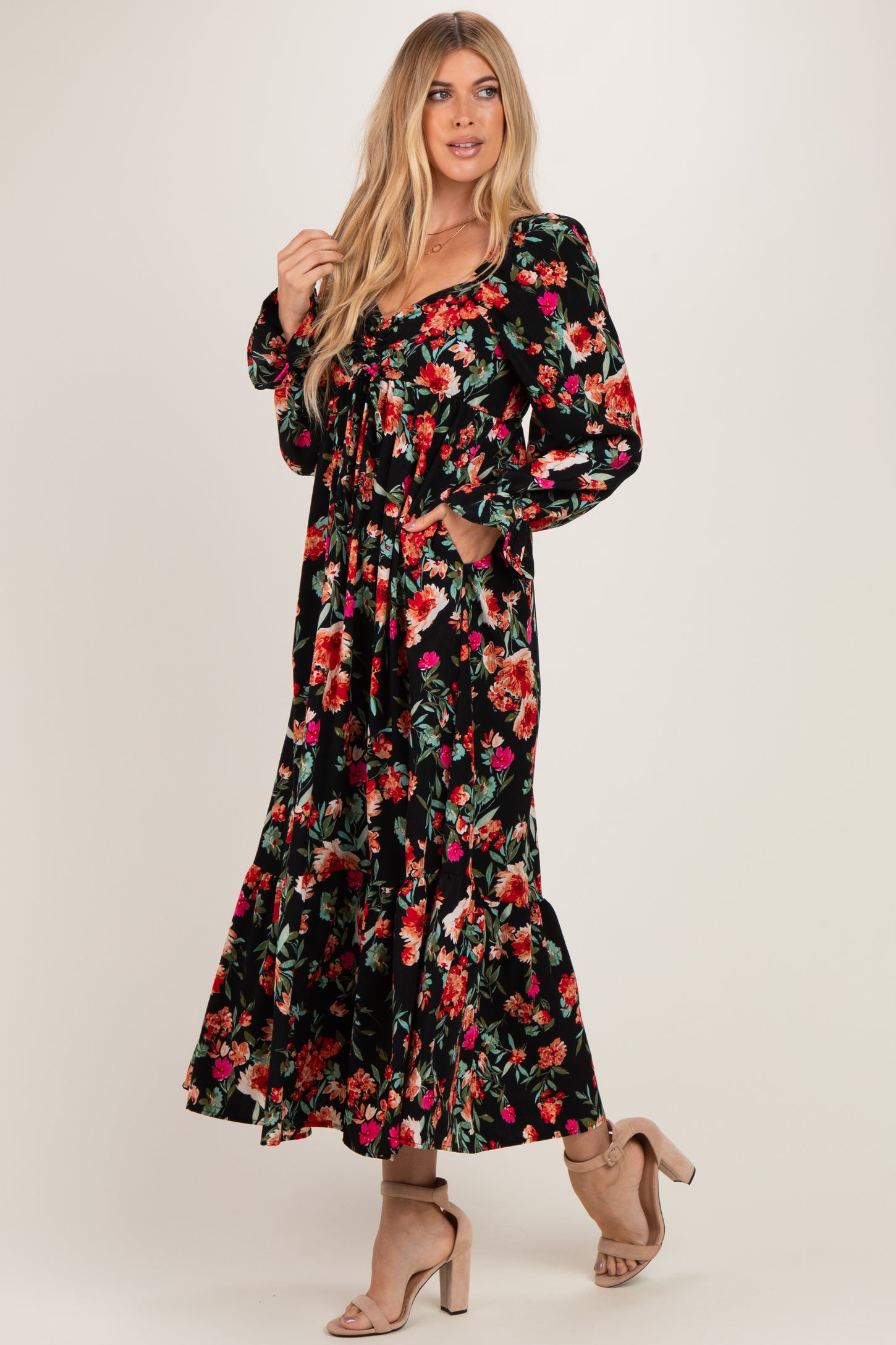 woman wearing a black floral long sleeve maxi dress with a gathered bodice and pockets
