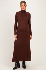 woman wearing a brown ribbed turtleneck maternity dress with long sleeves and a flowing silhouette