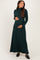 woman wearing a dark green long sleeve maternity maxi dress while holding her baby bump