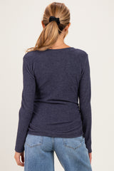 woman wearing a navy long sleeve maternity top, viewed from the back, with fitted styling and soft fabric