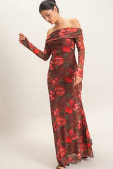 woman wearing a floral off-shoulder long sleeve gown in red and brown colors, posing with one hand raised