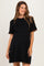 woman wearing a black maternity dress with short sleeves and contrasting trim, showing her baby bump