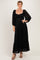 woman wearing a black lace maxi dress with long puff sleeves and a ruffled hemline
