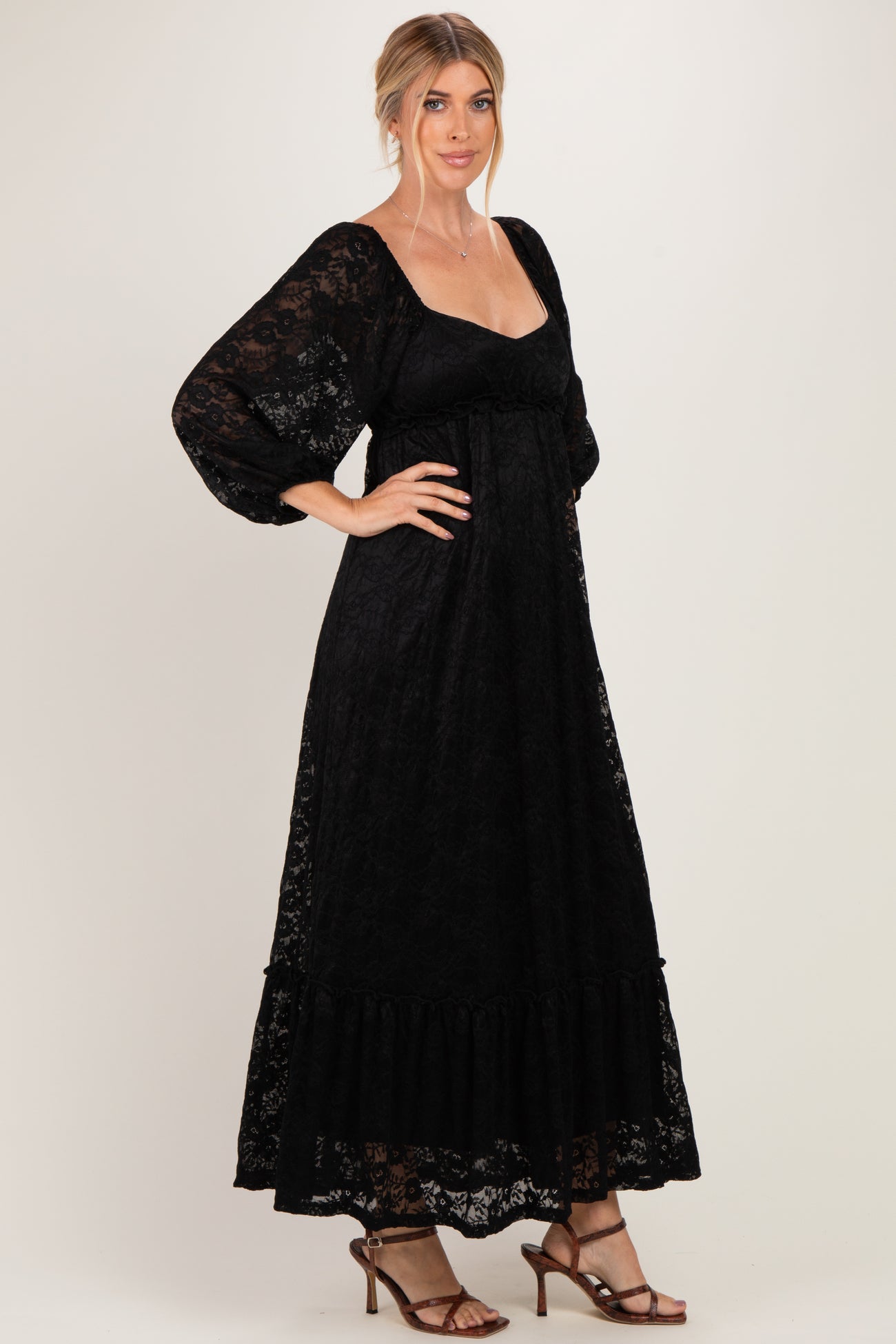 woman wearing a black lace long sleeve maxi dress with a ruffled hem and a square neckline