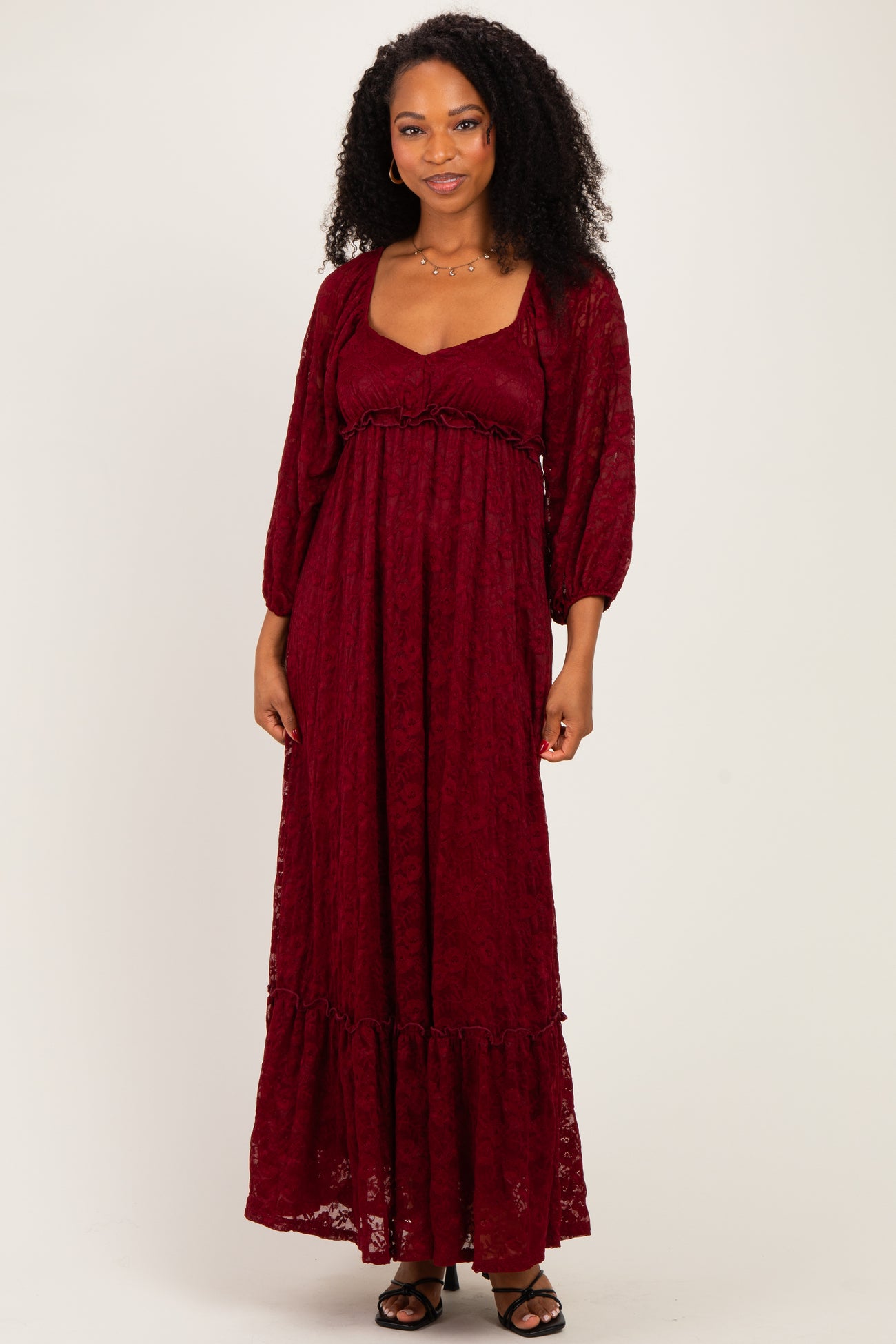 woman wearing a burgundy long sleeve lace maxi dress with a square neckline and ruffle hem
